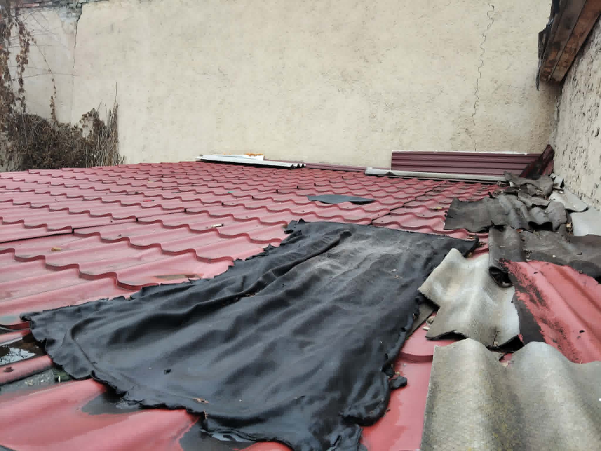 Tetősíkra helyezett rögtönzött vízterelő anyagok lemeztetőn