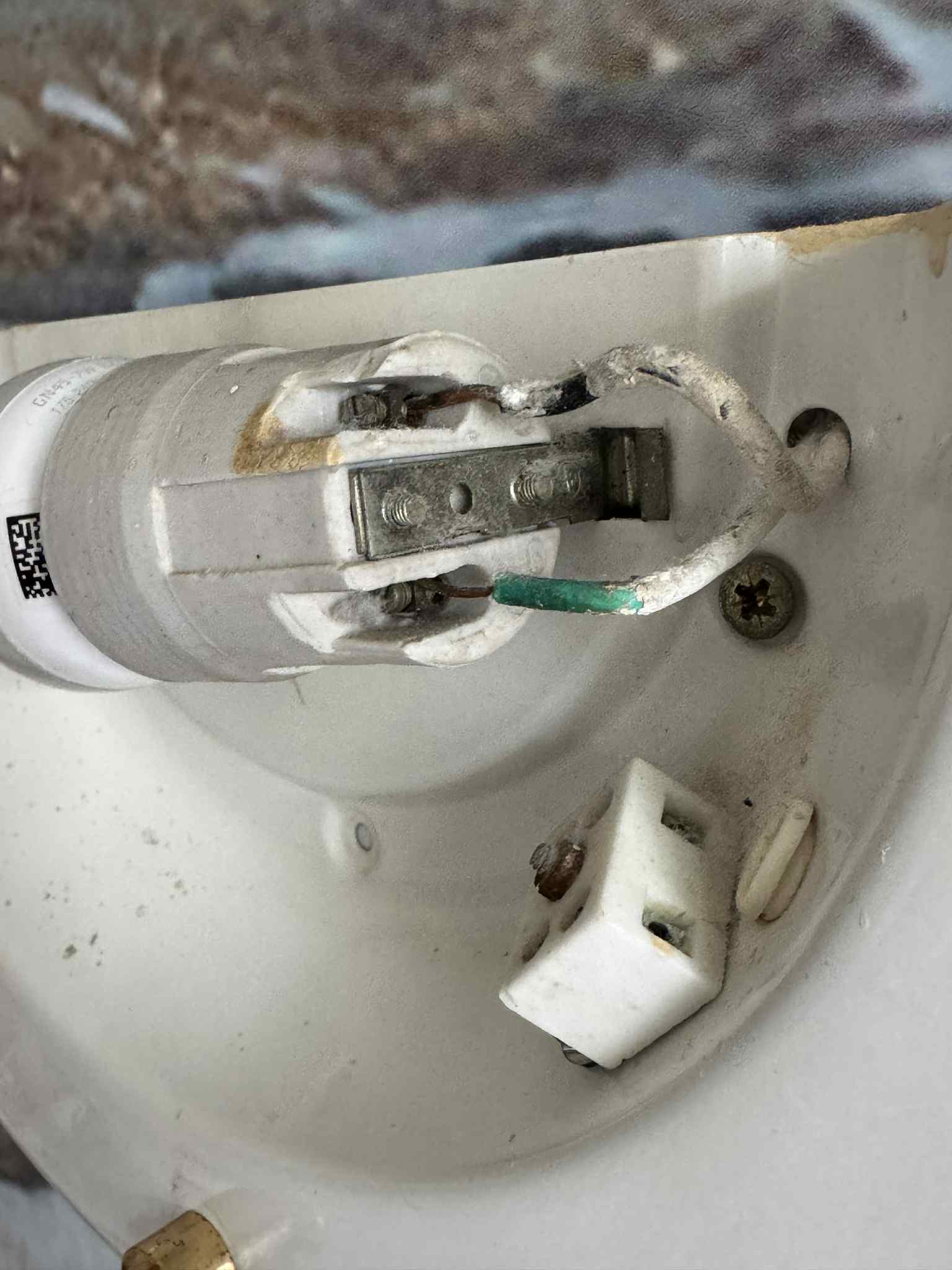 Közelkép búra nélküli lámpatest festett és sérült vezetékeiről